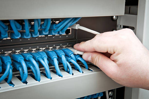 A person using a network hub and cable stock photo