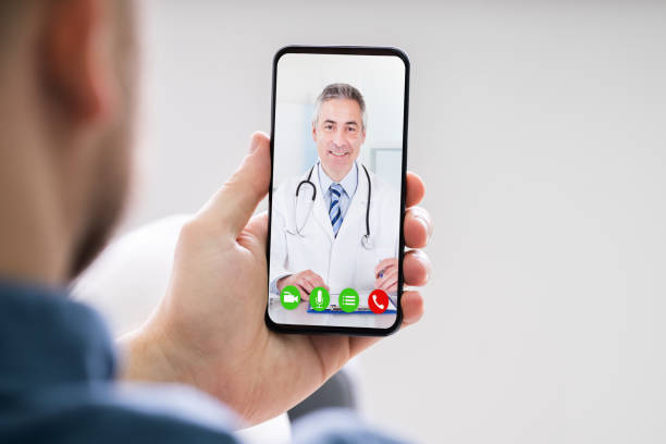 Person Videochatting With Doctor Person Videochatting With Doctor On Mobile Phone telemedicine stock pictures, royalty-free photos & images