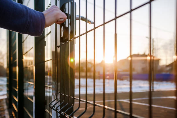 person wants get in on playground through the little gate of welded wire mesh stock photo