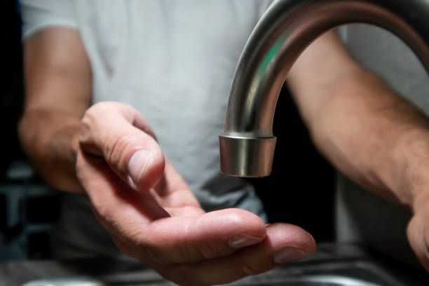 Person washes their hands at sink stock photo