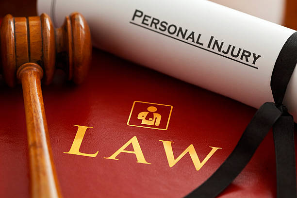 Personal Injury Red leather Personal Injury Law book and gavel with gold embossed type and stylised icon of figure with arm in a sling embossed on the book cover and a Personal Injury writ. Injury Lawyer stock pictures, royalty-free photos & images