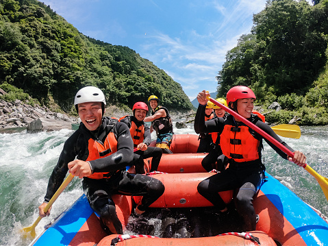 Personal point of view of a group of men and women while white water river rafting