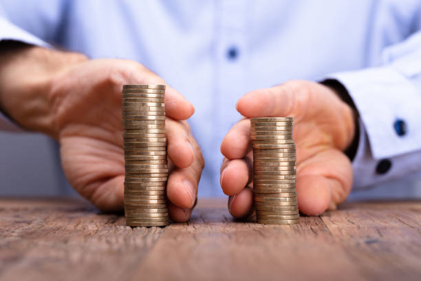 Person's Hand Holding Stack Of Coins Close-up Of A Person's Hand Holding Stack Of Coins division stock pictures, royalty-free photos & images