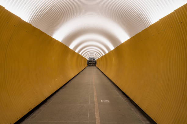 Perspective view of long modern futuristic yellow underground pedestrian tunnel in Stockholm Sweden. stock photo