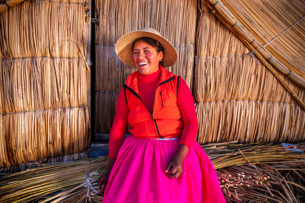 Peruvian woman on Uros floating island, Lake Tititcaca Peruvian woman on Uros floating island. Uros are a pre-Incan people that live on forty-two self-fashioned floating island in Lake Titicaca Puno, Peru and Bolivia. They form three main groups: Uru-Chipayas, Uru-Muratos  and the Uru-Iruitos. The latter are still located on the Bolivian side of Lake Titicaca and Desaguadero River. The Uros use bundles of dried totora reeds to make reed boats (balsas mats), and to make the islands themselves. The Uros islands at 3810 meters above sea level are just five kilometers west from Puno port. beautiful peruvian women stock pictures, royalty-free photos & images