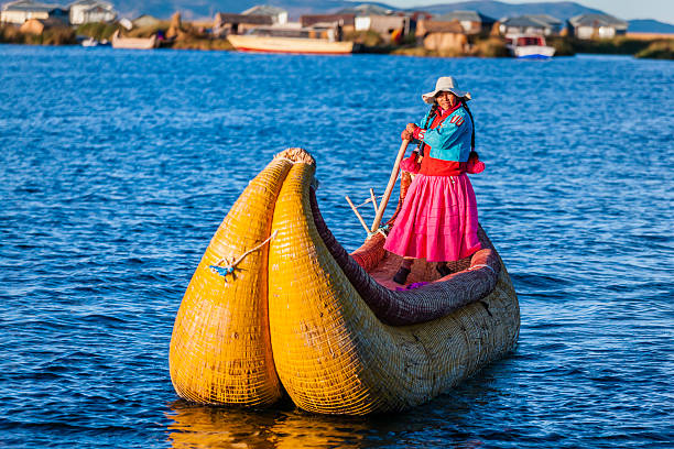 Peruvian woman sailing between Uros floating islands, Lake Tititcaca Peruvian woman sailing between Uros floating islands. Uros are a pre-Incan people that live on forty-two self-fashioned floating island in Lake Titicaca Puno, Peru and Bolivia. They form three main groups: Uru-Chipayas, Uru-Muratos  and the Uru-Iruitos. The latter are still located on the Bolivian side of Lake Titicaca and Desaguadero River. The Uros use bundles of dried totora reeds to make reed boats (balsas mats), and to make the islands themselves. The Uros islands at 3810 meters above sea level are just five kilometers west from Puno port.http://bem.2be.pl/IS/peru_380.jpg beautiful peruvian women stock pictures, royalty-free photos & images