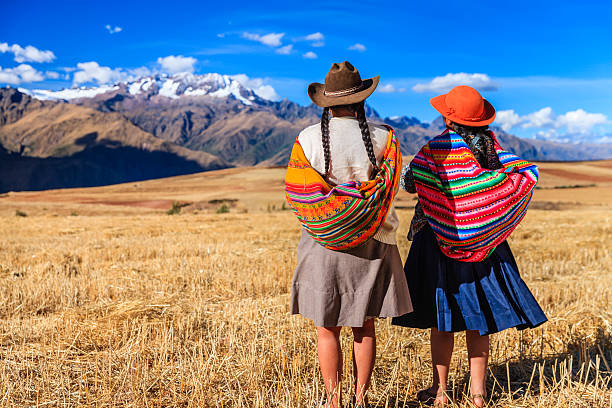peruvian women in national clothing crossing field, the sacred valley - peru stok fotoğraflar ve resimler