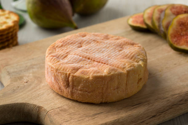 Petit Munster cheese close up Whole ripe petit Munster cheese close up and fresh figs on the background for dessert munster france stock pictures, royalty-free photos & images