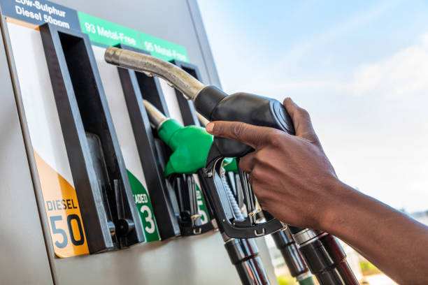 Petrol attendant, seen close up at a petrol garage, choosing a diesel pump stock photo