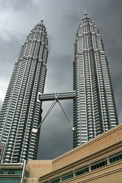 Petronas Twin Towers Looking up to Kuala Lumpur's Petronas Twin Towers on a cloudy day. central market kuala lumpur stock pictures, royalty-free photos & images