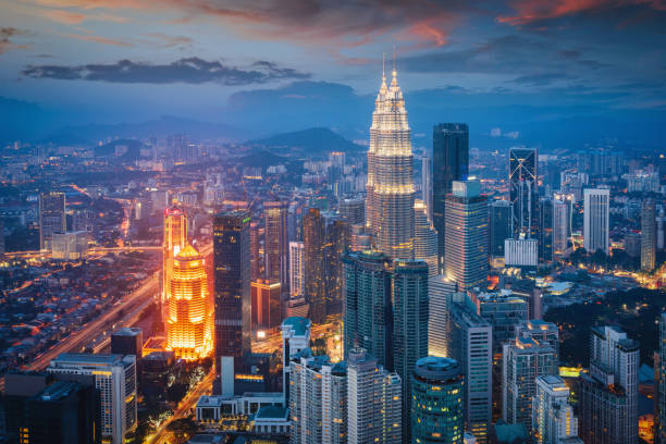 Petronas Twin Towers Sunset Twilight Kuala Lumpur Illuminated Cityscape Kuala Lumpur Cityscape view towards the iconic Petronas Towers in downtown Kuala Lumpur during a colorful vibrant twilight after sunset. Kuala Lumpur, Malaysia, Asia kuala lumpur stock pictures, royalty-free photos & images