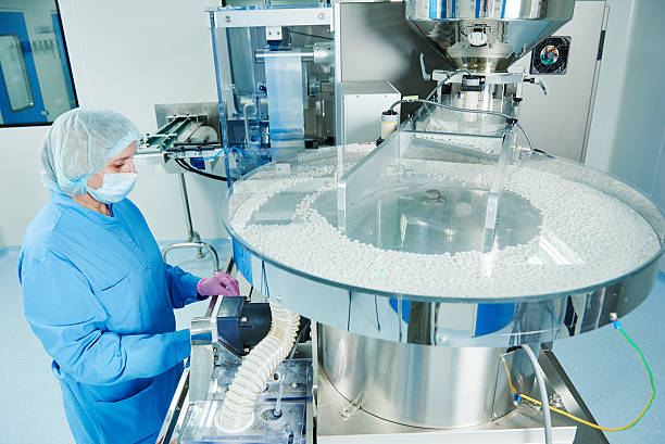 Pharmaceutics. Pharmaceutical worker operates tablet blister packaging machine stock photo