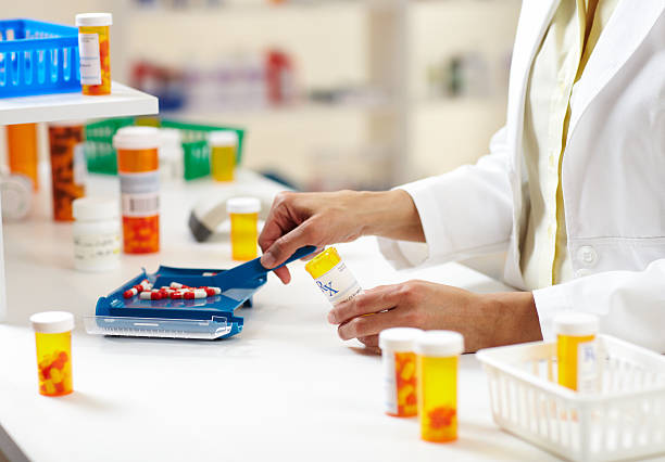farmacista riempimento prescrizione di pillole - farmacia foto e immagini stock