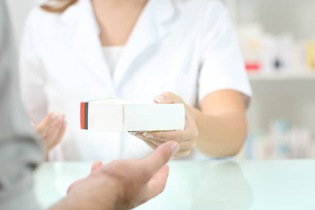 Pharmacist giving a medicament to a customer Close up of a pharmacist hand giving a medicament to a customer generic drug stock pictures, royalty-free photos & images
