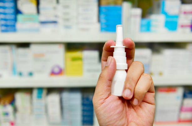 pharmacist holding nasal spray medicine Close up shot pharmacist holding nasal spray medicine at the drugstore.Seasonal health issues allergy medicine stock pictures, royalty-free photos & images