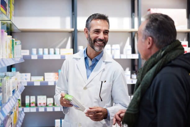 A pharmacist is attending a senior man. stock photo