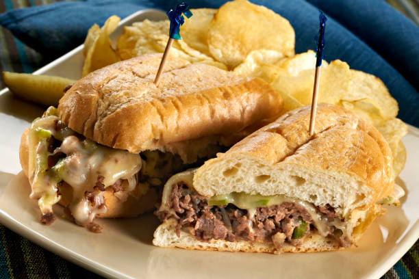 Philadelphia Cheese Steak Sandwich Philadelphia Cheese Steak Sub Sandwich with chips and a pickle. burwellphotography stock pictures, royalty-free photos & images