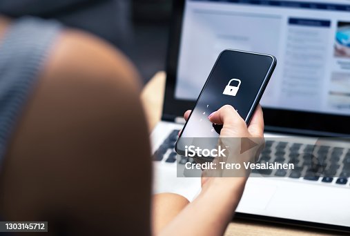 istock Phishing, mobile phone hacker or cyber scam concept. Password and login pass code in smartphone. Online security threat and fraud. Female scammer with cellphone and laptop. 1303145712