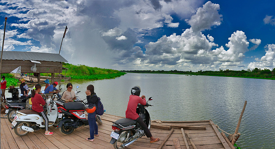 Phnom Penh, Cambodia -cars, motorbikes and people on a ferry crossing the Mekong river