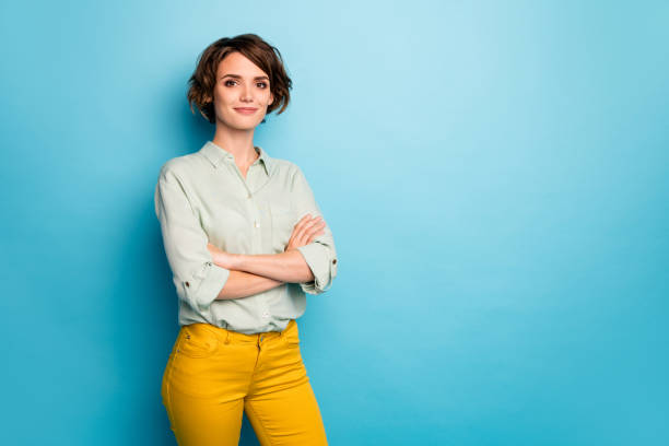 Photo of attractive pretty business lady short hairstyle friendly smiling responsible person arms crossed wear casual green shirt yellow pants isolated blue color background Photo of attractive pretty business lady short hairstyle friendly smiling, responsible person arms crossed wear casual green shirt yellow pants isolated blue color background confidence stock pictures, royalty-free photos & images