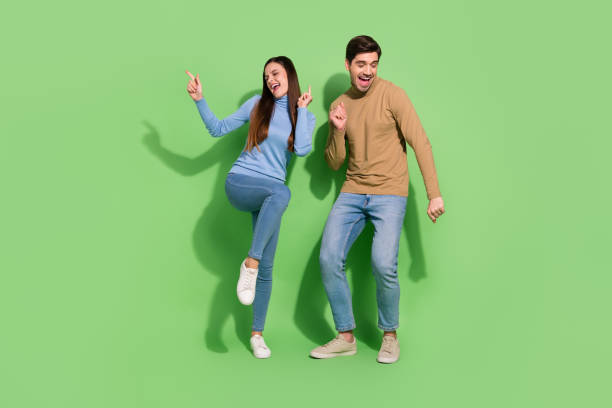 Photo of carefree positive couple enjoy festive disco atmosphere wear casual outfit isolated green color background stock photo