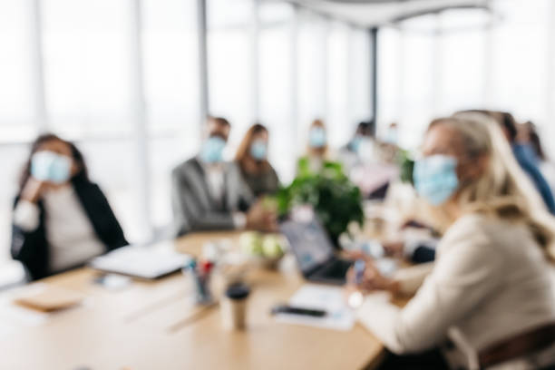 Photo of co-workers at a business meeting wearing face masks stock photo