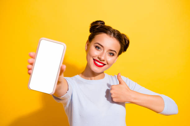 Photo of funky confident lady wear long sleeve showing modern gadget touch screen empty space isolated yellow color background stock photo