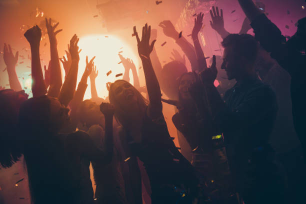 photo of many party people buddies dancing yellow lights confetti flying everywhere nightclub event hands raised up wear shiny clothes - discoteca danca imagens e fotografias de stock