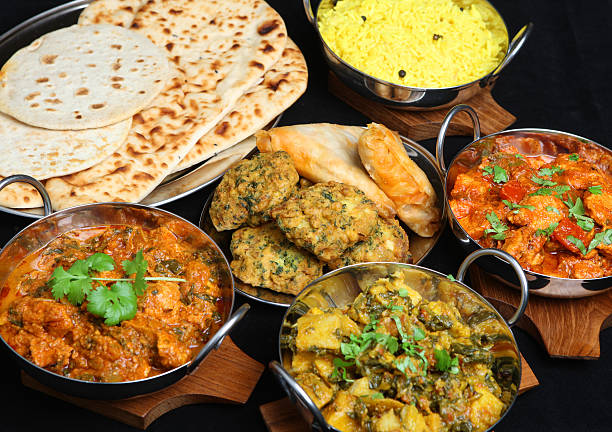 Photo of plates of different types of Indian food Indian food with curries, rice, naan bread, samosas and pakora. indian food stock pictures, royalty-free photos & images
