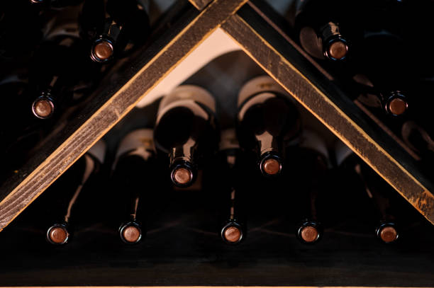 photo of wine bottles stacked on wooden racks in cellar close up photo of wine bottles stacked on wooden racks in cellar moldova stock pictures, royalty-free photos & images