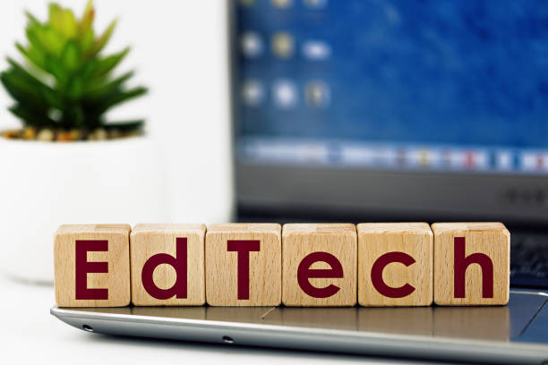 photo on EdTech theme. wooden cubes with the words "EdTech",  on the background of laptop and succulent stock photo
