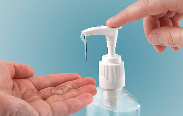 Photograph of a finger pumping sanitizer onto hand Pumping hand sanitizer into hand. cleaning product stock pictures, royalty-free photos & images