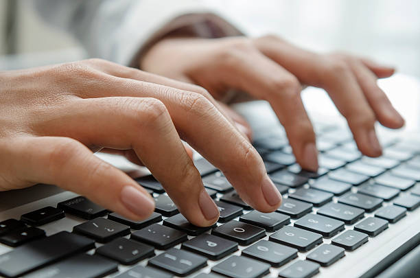 Photograph of hands working on data entry with keyboard stock photo