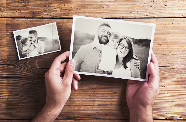 Photos on a table Black and white family photos laid on wooden floor background. table photos stock pictures, royalty-free photos & images