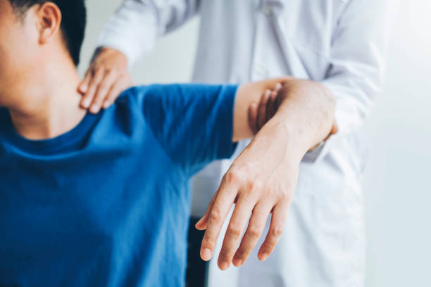 physikalische arztberatung mit patient über schulschwung-schmuskelschmerzen probleme physikalische therapie diagnose konzept - osteopathie stock-fotos und bilder