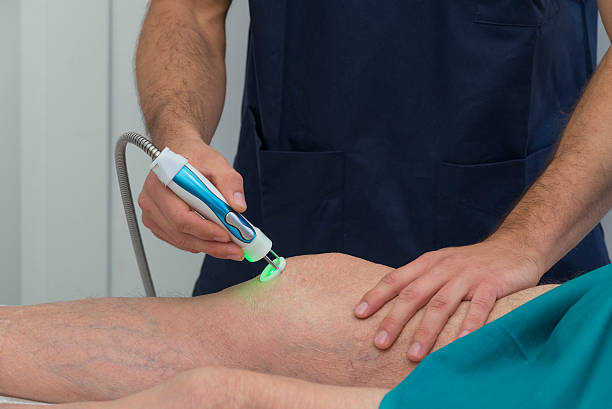 Physical therapist aiding a patient's knee in rehabilitation stock photo
