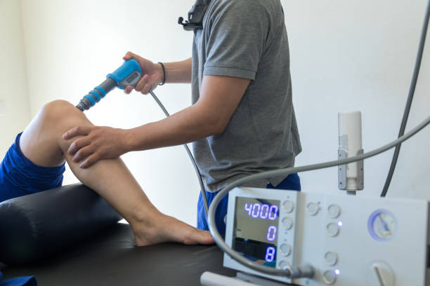 physical therapy of the knee and the foot with shock wave stock photo
