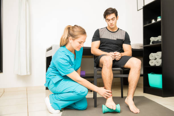 Physiotherapist Treating Plantar Fasciitis In Athlete Full length of young physiotherapist treating plantar fasciitis in athlete at hospital plantar fasciitis stock pictures, royalty-free photos & images