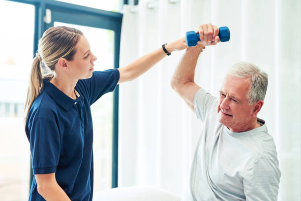 Physiotherapy, arm and senior man with help and support on recovery, rehabilitation or motion training. Healthcare woman or physiotherapist helping elderly person with dumbbell fitness exercise Physical therapy, woman and senior man with help and support on recovery, rehabilitation or motion training. Healthcare girl or physiotherapist helping elderly person with dumbbell fitness exercise physical therapy programs stock pictures, royalty-free photos & images