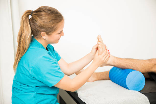 Physiotherapy Professional Massaging Patient's Foot Female physiotherapy professional massaging patient's foot in clinic plantar fasciitis stock pictures, royalty-free photos & images