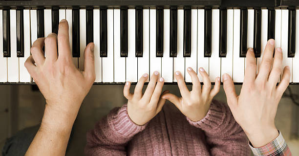 Piano Keyboard top View and Hands of Child Mother Father stock photo