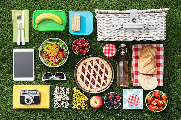 Picnic on the grass Summertime picnic on the grass with basket, salad, fruit and accessories, flat lay neat photos stock pictures, royalty-free photos & images