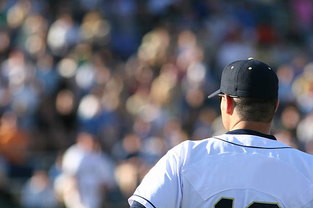 A picture of a baseball player and a white jersey a baseball player, with fans blurred in background baseball sport stock pictures, royalty-free photos & images