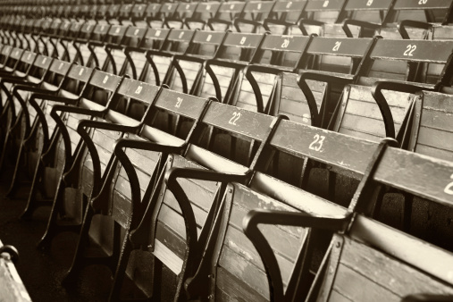 Old Time stadium seats in gray scale with a sepia tone. Shallow DOF focal point is the number 