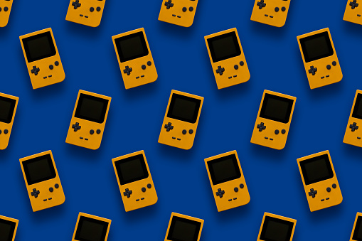 Picture of retro yellow game console pattern on blue background. Vintage video games