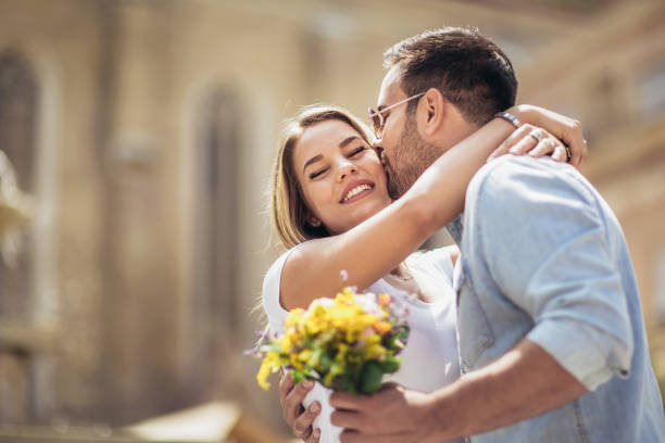Picture of young man surprising woman with flowers Picture of young man surprising woman with flowers falling in love stock pictures, royalty-free photos & images