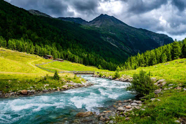 Picturesque Alpine Landscape With Old Farmhouse And Clear River In Deferegental In Tirol In Austria stock photo