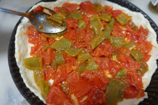 Pie with piperade  Crushed tomatoes and fried peppers  Pie before baking stock photo