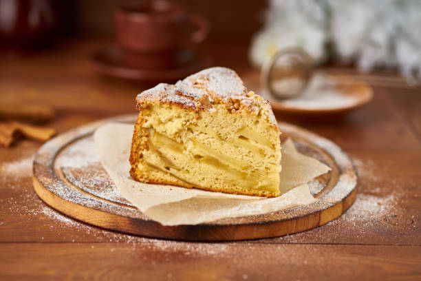 Piece of Apple french cake with apples, cinnamon on dark wooden kitchen table, side view stock photo