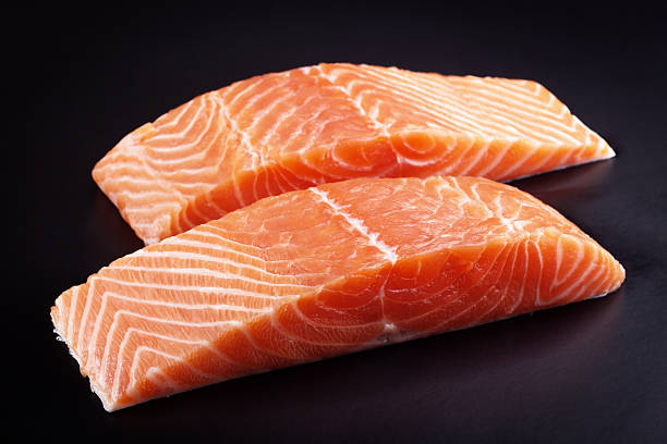 Piece of raw fresh salmon isolated on black background stock photo